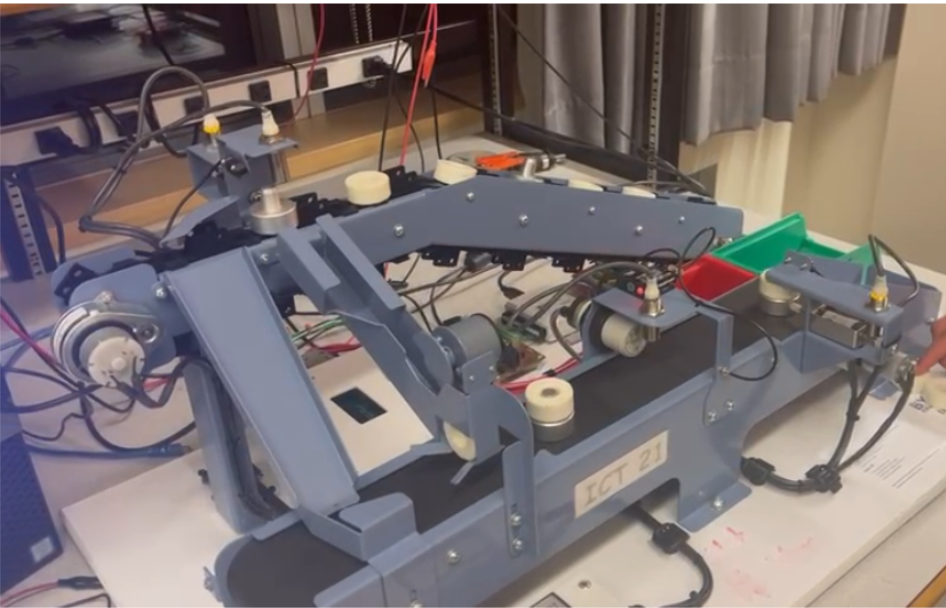 Conveyor sorting robot rig — bench-top assembly with belts, rollers, sensors, wiring.
