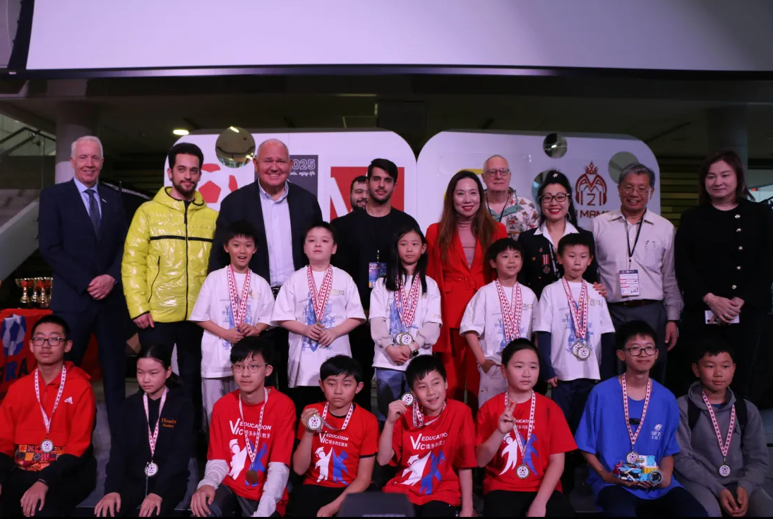 Coaching at robotics competition — group photo with students and adults.